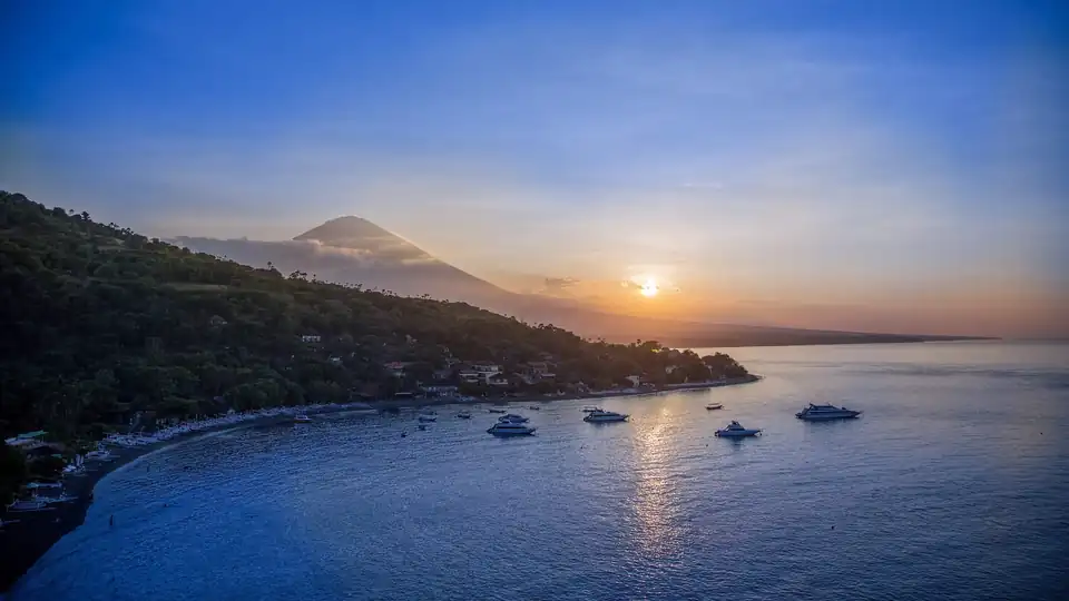 Black volcanic sand and fishing boats on the quiet shore at Amed