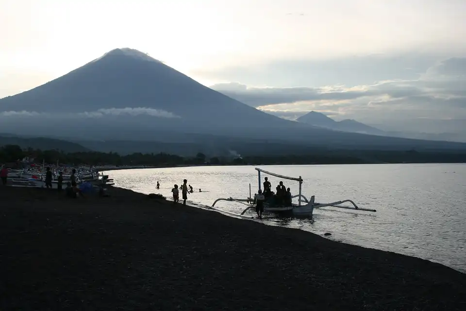Amed's dark-sand beach at sunset with fishing boats