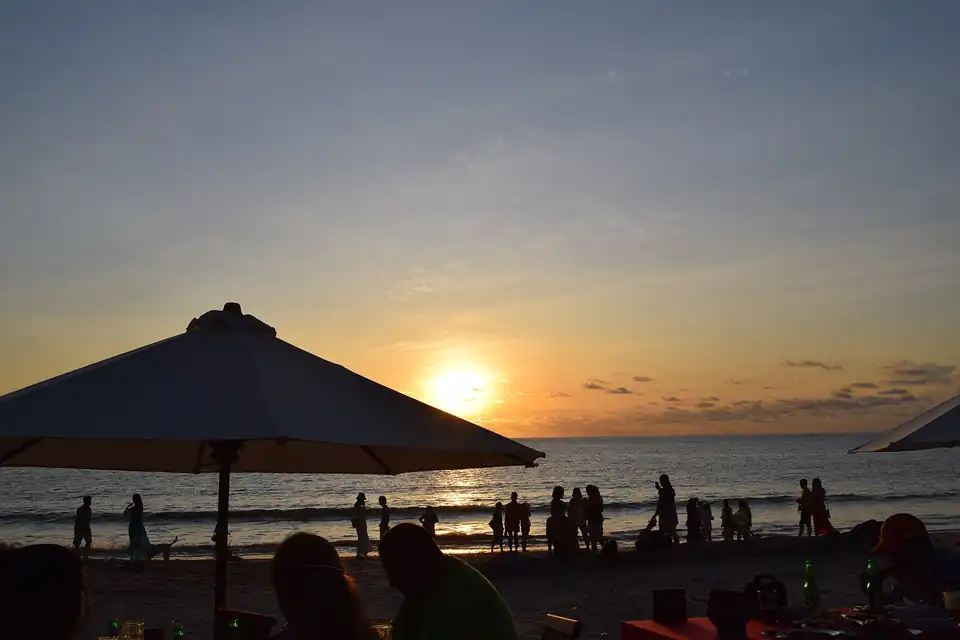 Seafood tables under umbrellas on Jimbaran beach at dusk