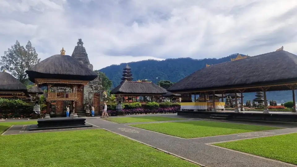 Thatched shrines and a carved gateway in the temple courtyard at Beratan