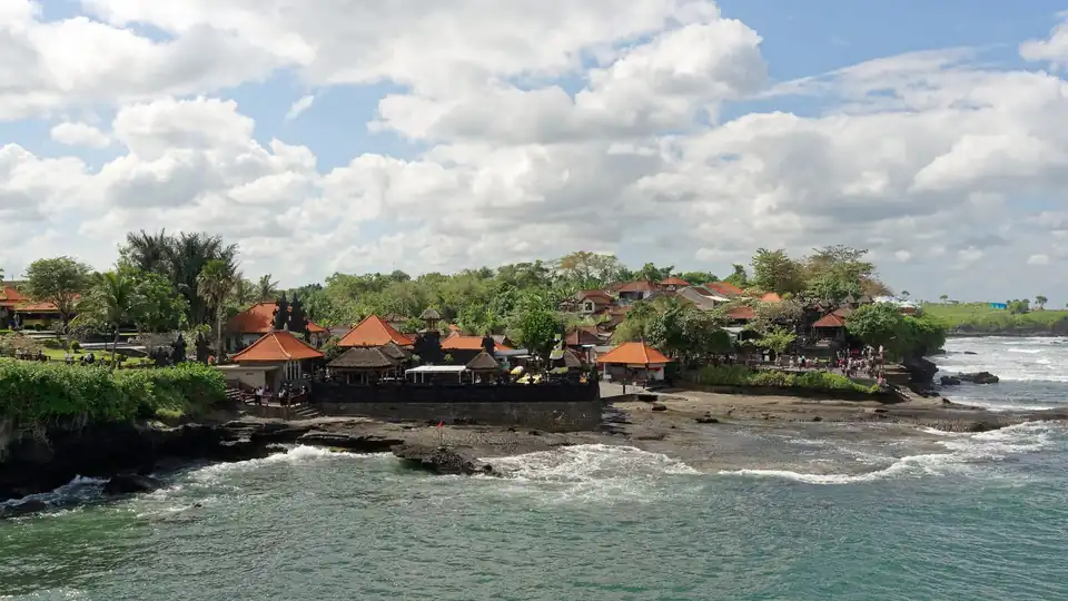 Surf and dark volcanic sand at Batu Bolong beach in Canggu