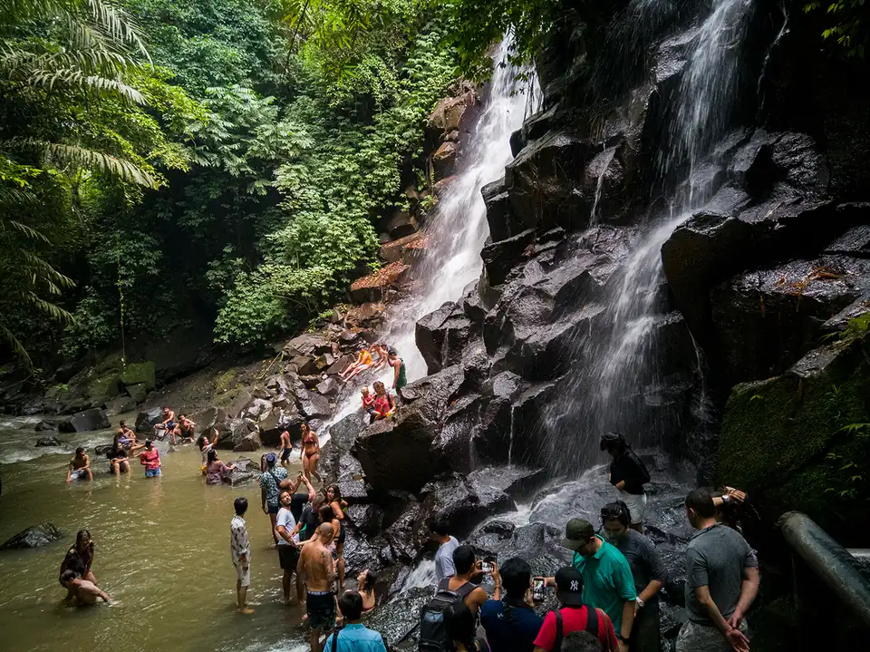 Bathers below Kanto Lampo waterfall, which spills over stepped rock