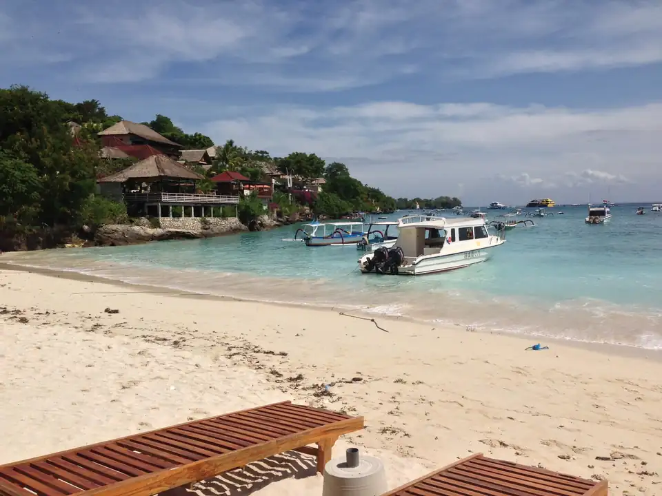 A white-sand beach with boats moored offshore