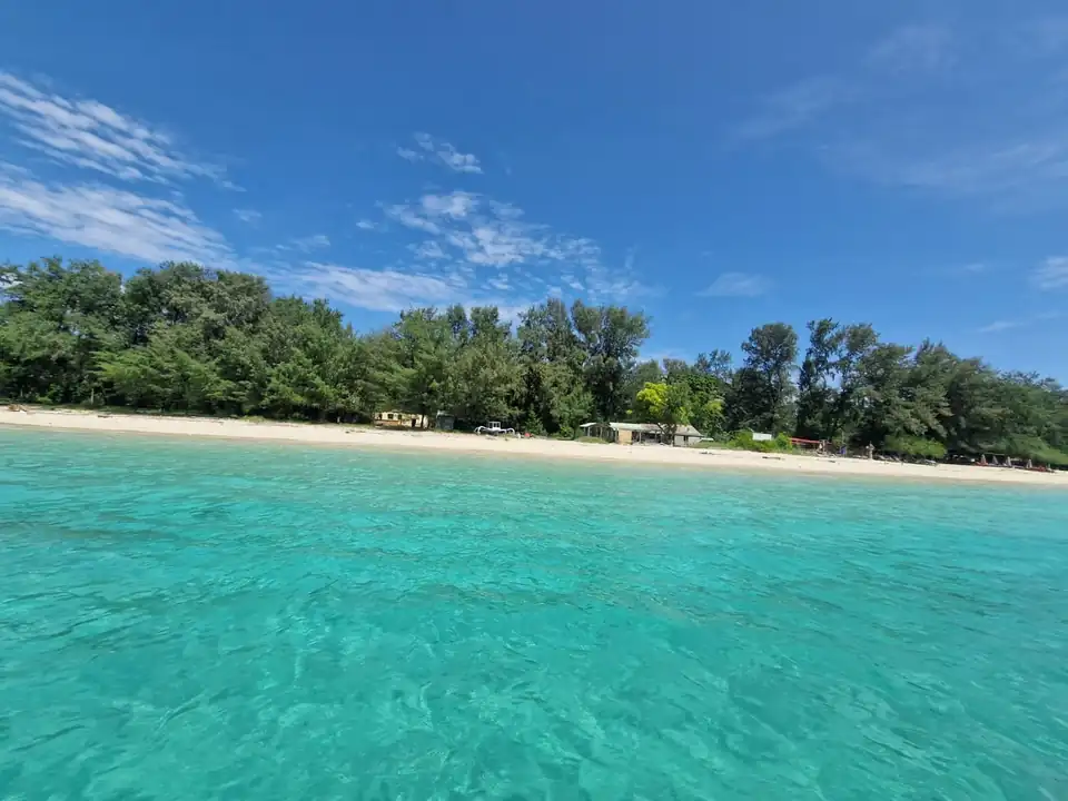 The pale reef flat between the beach and deeper blue water