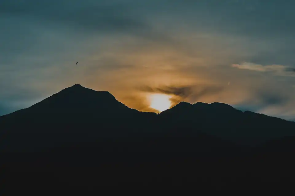 Mount Batur in silhouette with the sky lit behind it