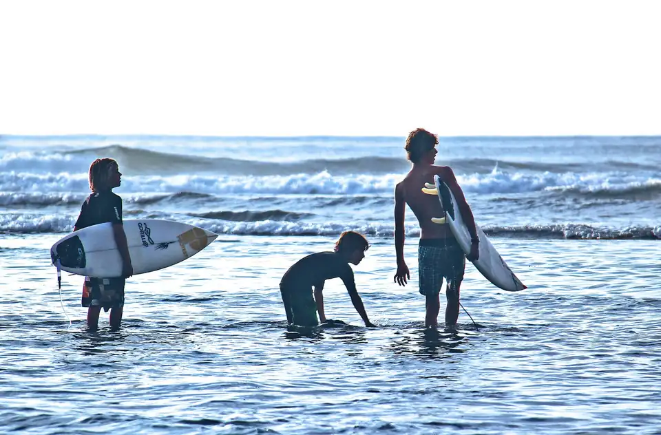 Young surfers at the water's edge in Bali