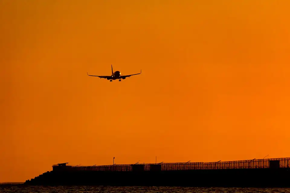A plane coming in to land at Ngurah Rai airport at sunset