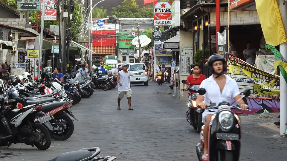A scooter rider in a helmet on a street in Bali