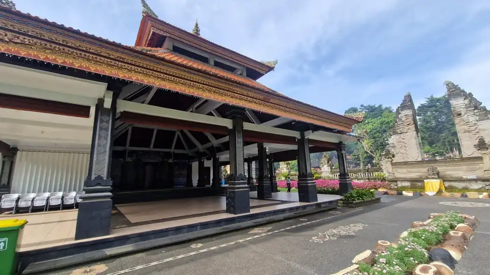 A carved and gilded open pavilion with a banner announcing an arts and culture festival