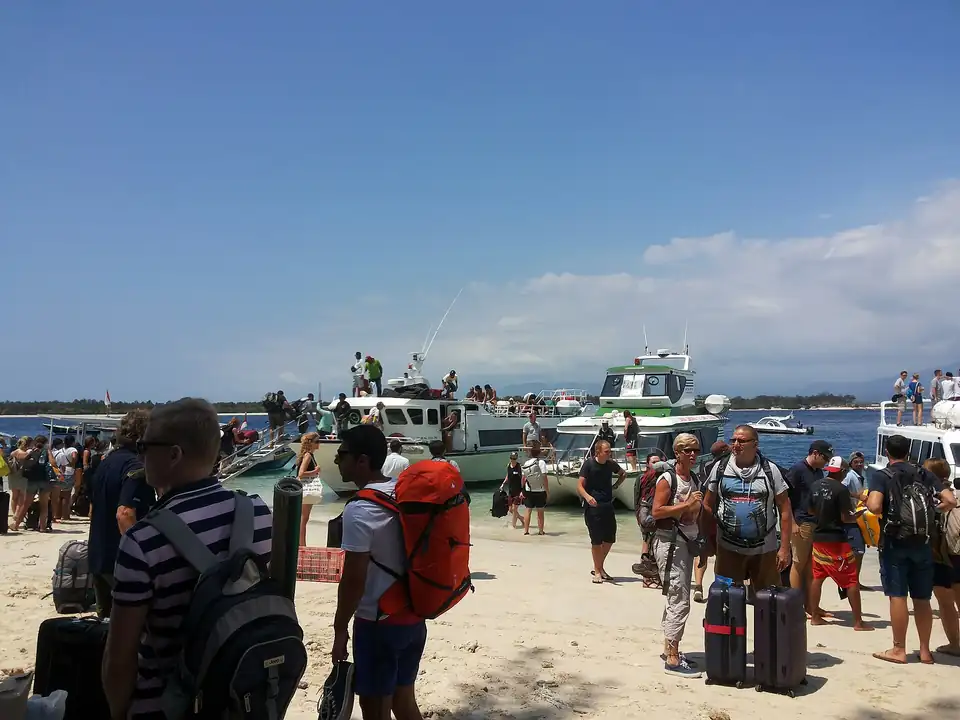Passengers and luggage on the beach at a fast boat landing on the Bali to Gili route
