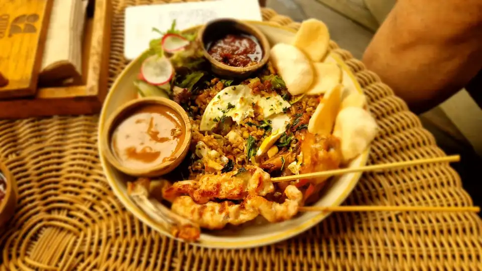 Nasi goreng served with chicken satay, prawn crackers, peanut sauce and sambal