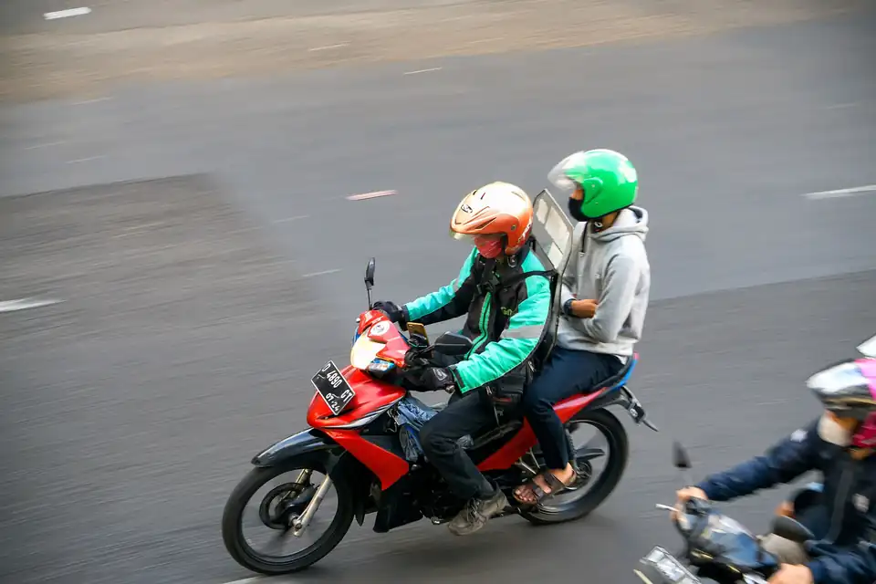 An app motorbike taxi carrying a passenger in Indonesia