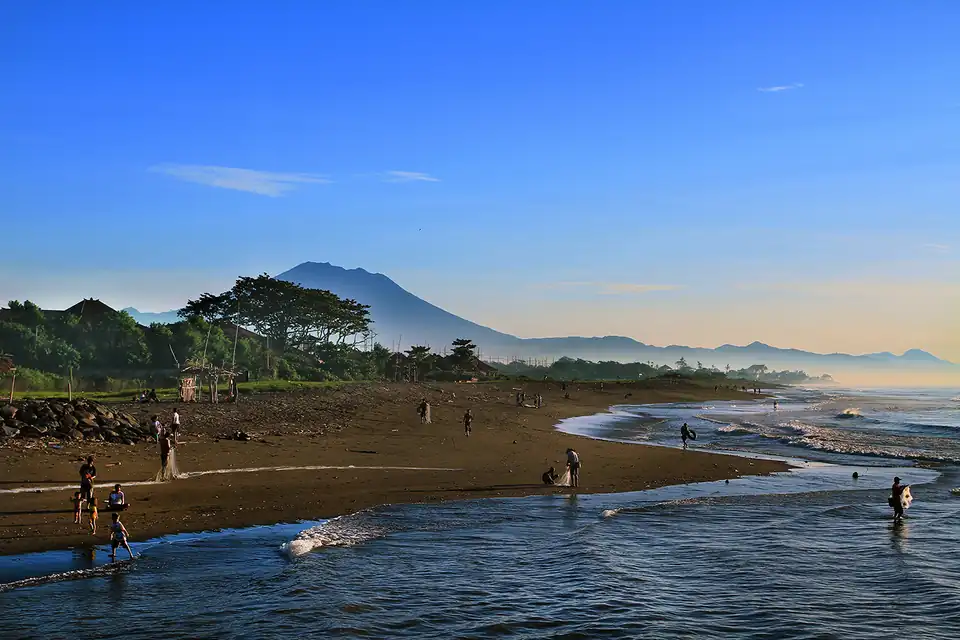 Mount Agung behind a dark-sand fishing beach in east Bali