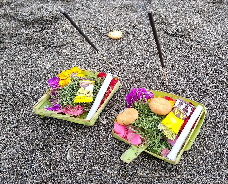 Two canang sari offerings on the sand at Canggu