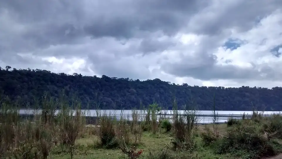 A lake below the hills at Munduk under cloud