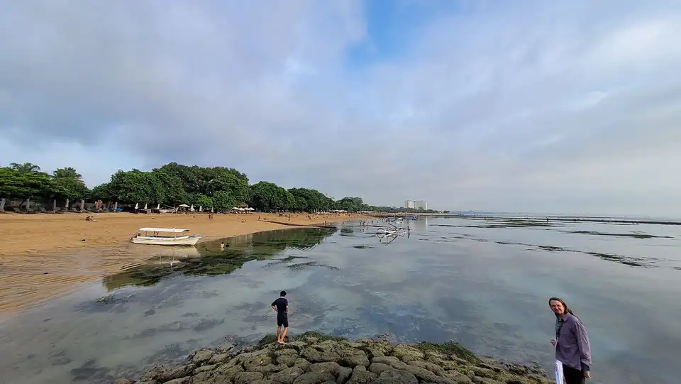 The shore at Sanur at low tide, with boats moored off the reef