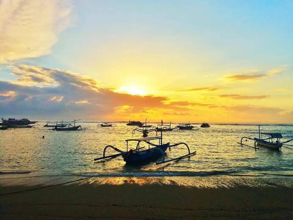Sunrise over the water and the jukung boats at Sanur
