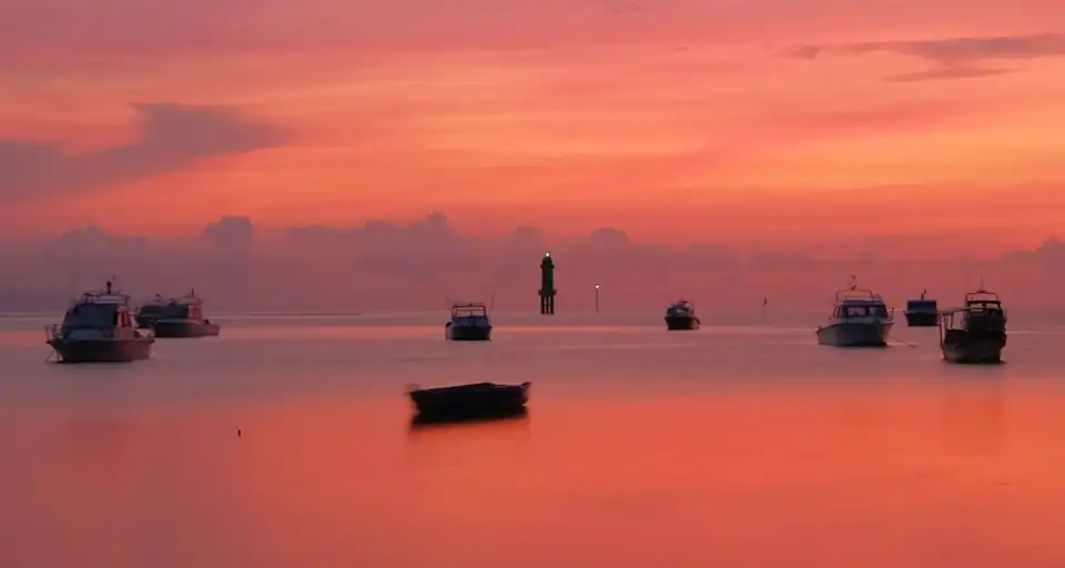 Boats moored off Sanur in the pink light of early morning